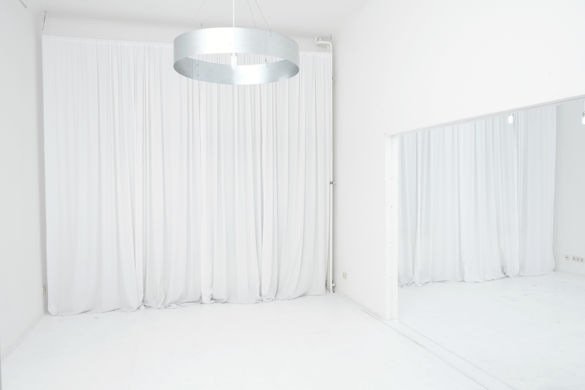 Bright white cyclorama and curtained windows inside Studio Blanc